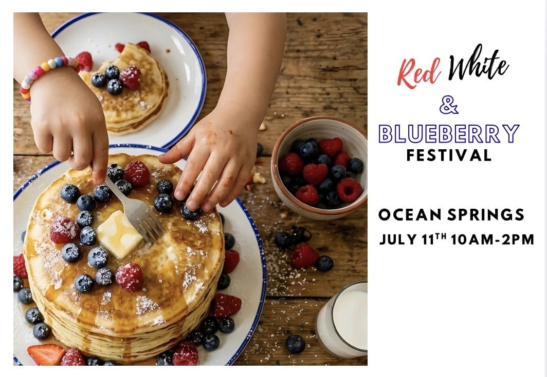 A child’s hands add berries and butter to a stack of pancakes on a wooden table with berries, milk, and pancakes; text advertises the Red White & Blueberry Festival in Ocean Springs, July 11, 10AM-2PM.